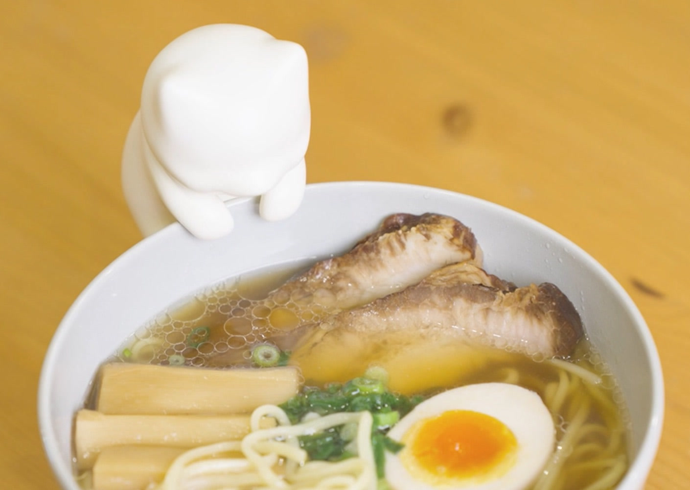 Nékojita FuFu cat robot clipped to a mug blowing to cool hot drink