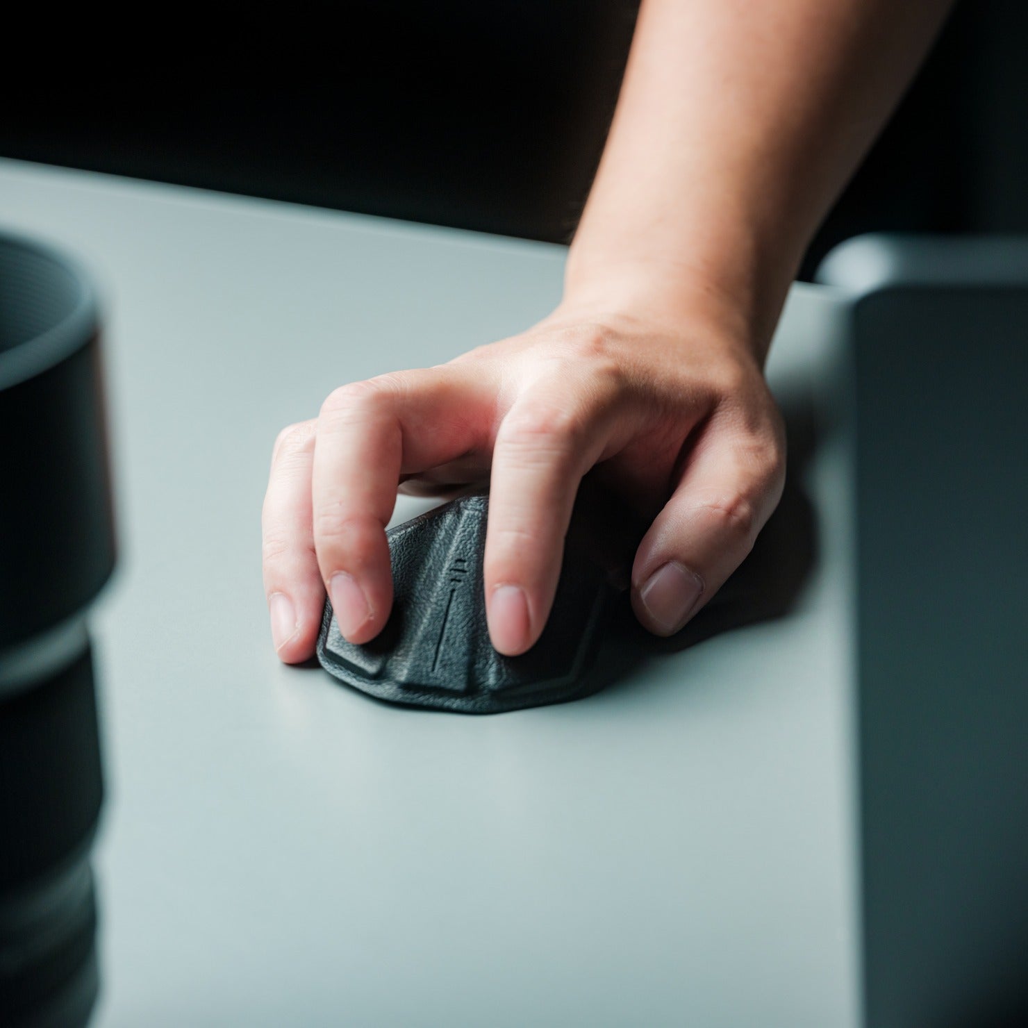 Hand using an OrigamiSwift foldable mouse on a desk