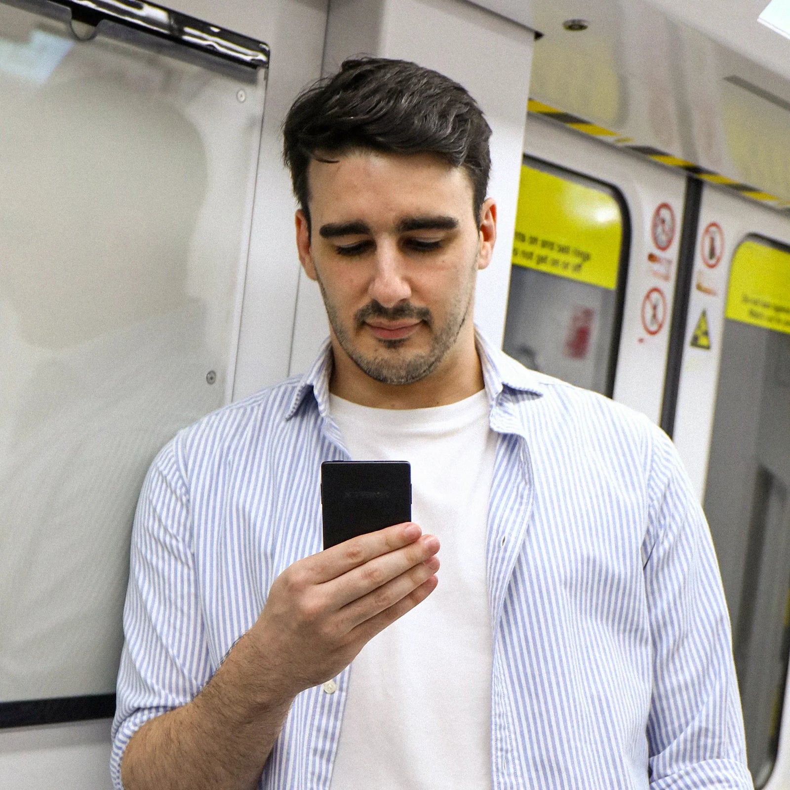 XTEINK X3 e-ink reader magnetically attached to the back of a smartphone in hand