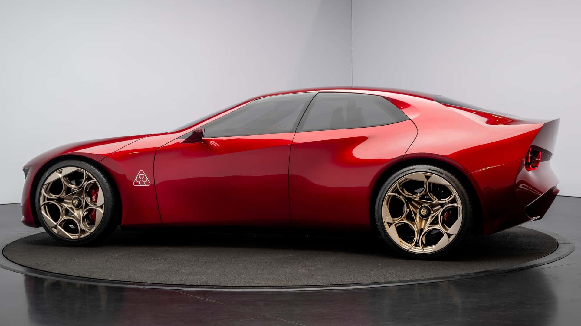 Red Alfa Romeo Cuorerosso concept fastback in side profile on a turntable in the studio