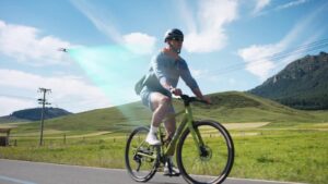 Cyclist riding a country road while an Antigravity A1 drone follows and films him