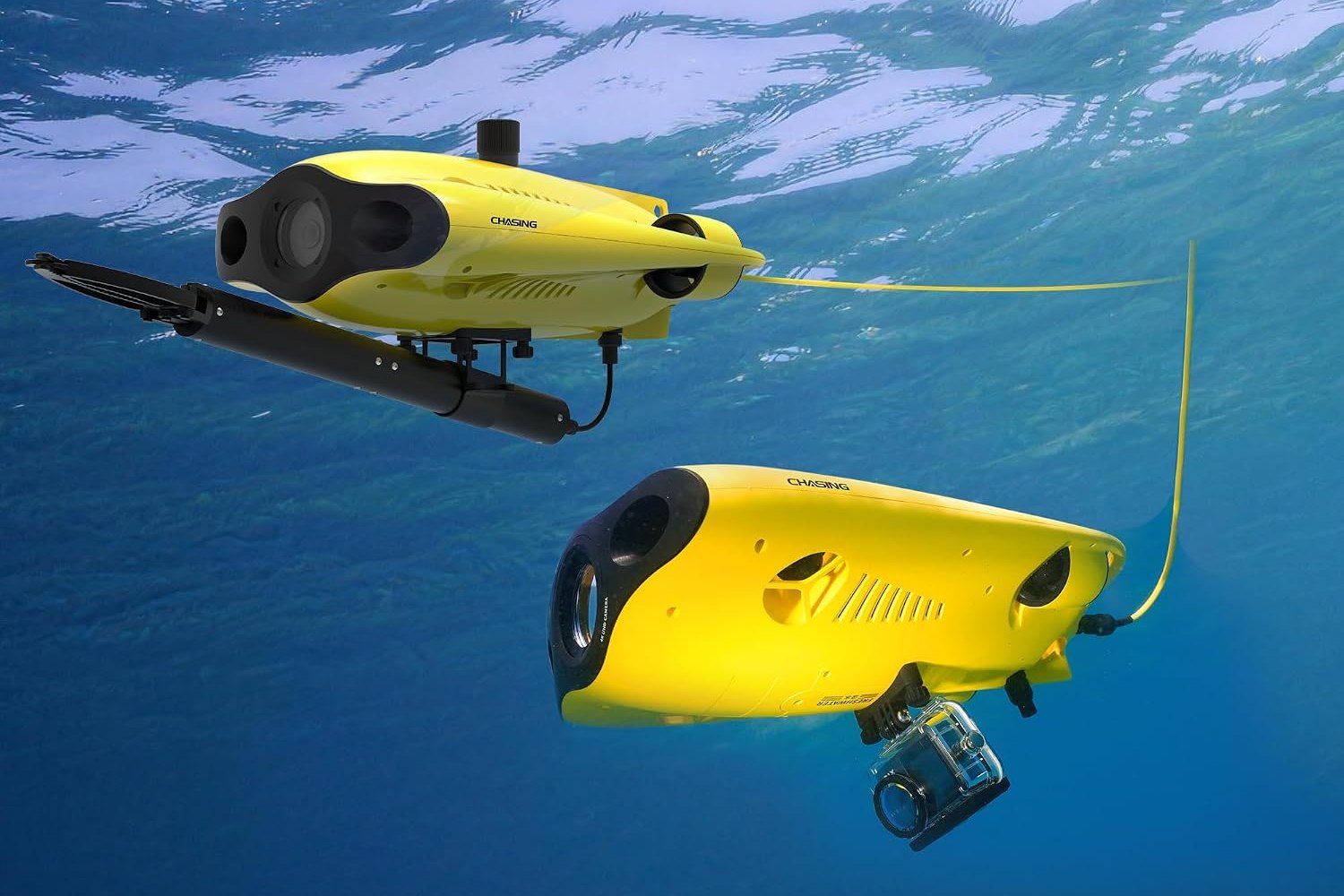 Yellow CHASING Gladius Mini S underwater drone with a grabber claw, next to a second Mini S carrying an action camera