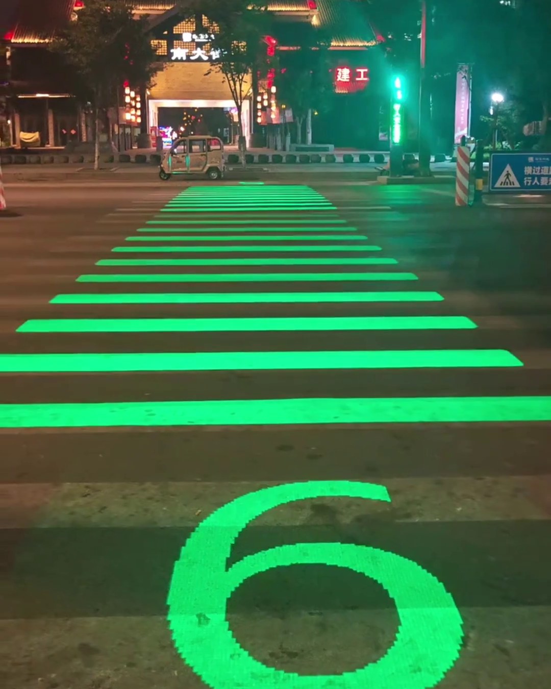 Smart LED crosswalk glowing green at night with a large 5 second countdown on the road