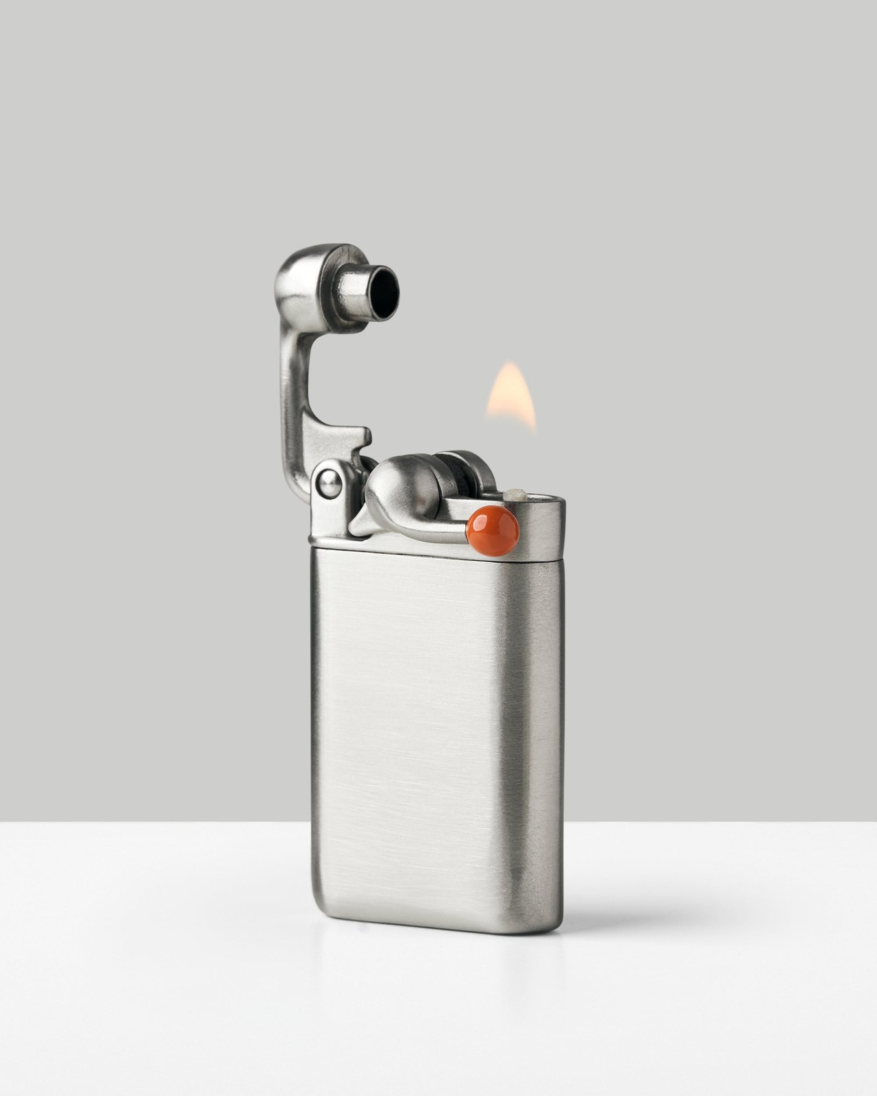 Craighill Swingtop pocket lighter in stainless steel with its top swung open and a flame burning