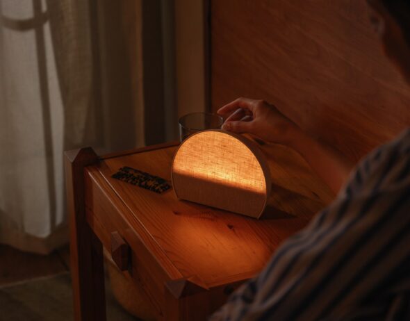 Hatch Sleep Clock glowing on a wooden nightstand at bedtime