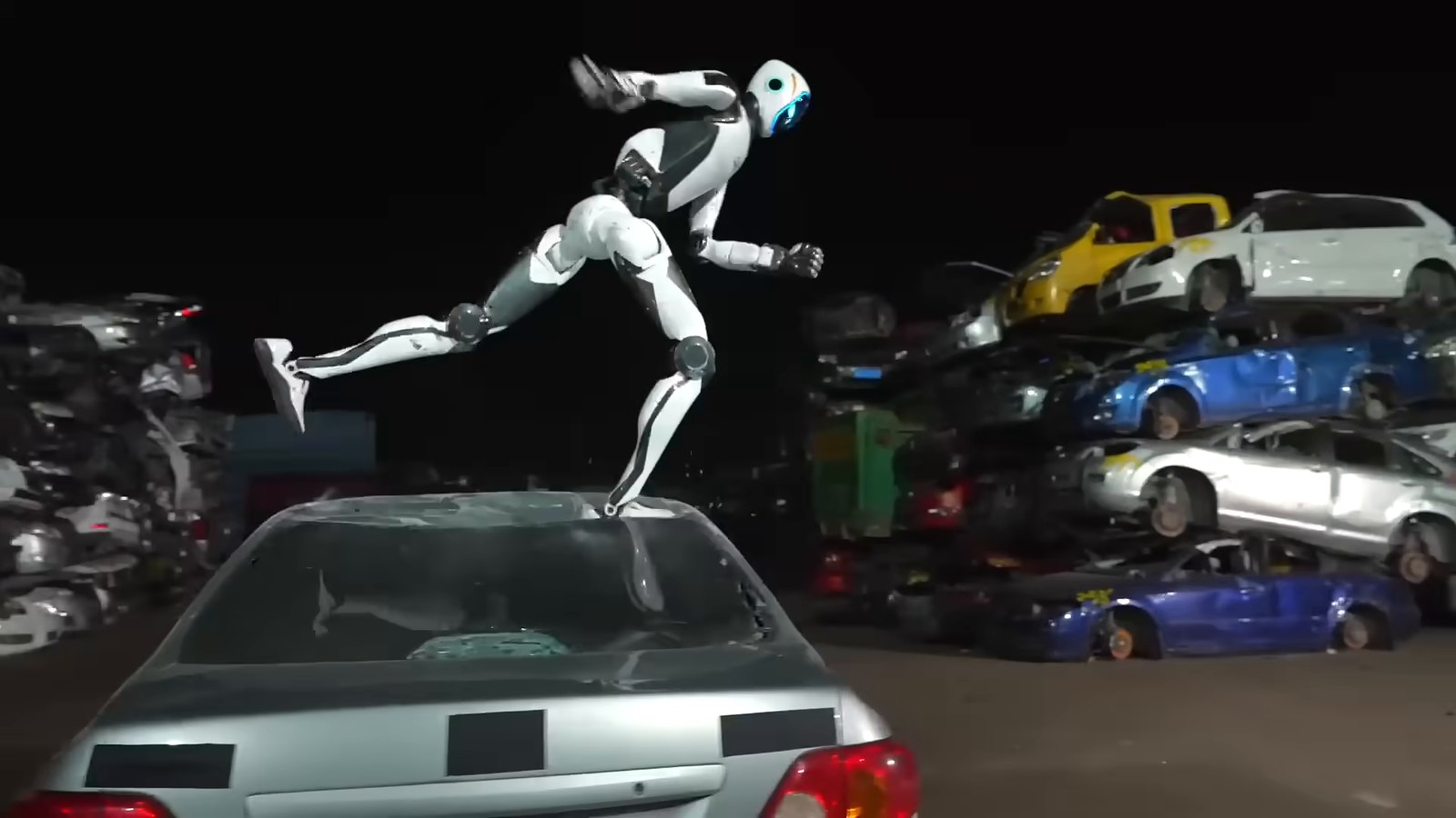 Unitree H2-X humanoid robot leaping off the roof of a silver car in a junkyard at night