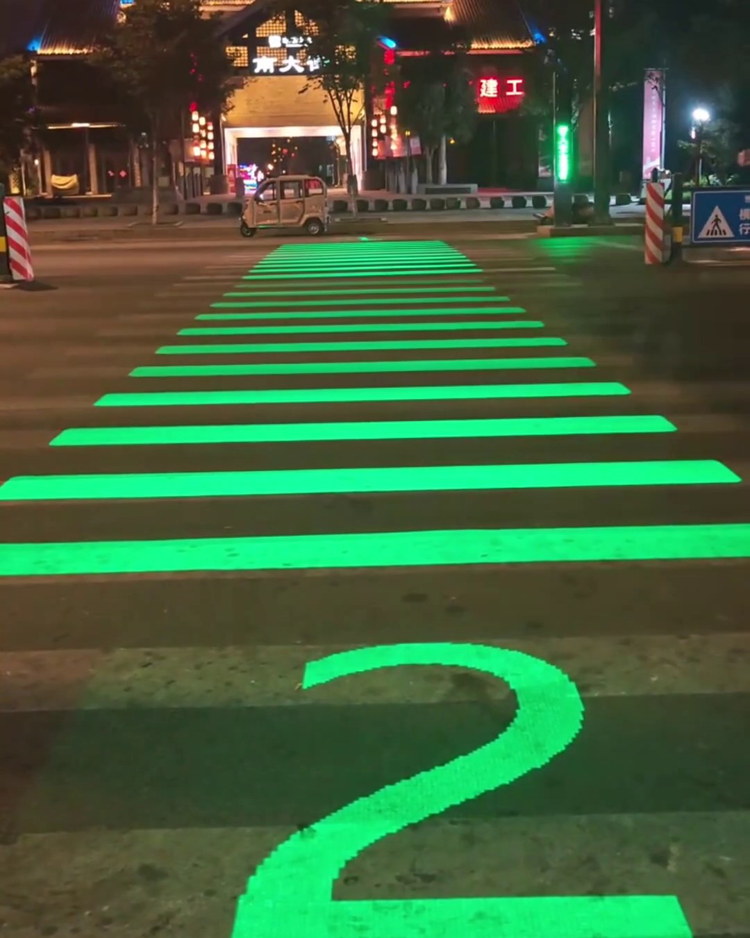 Glowing green zebra crossing counting down to 1 at a Chinese intersection