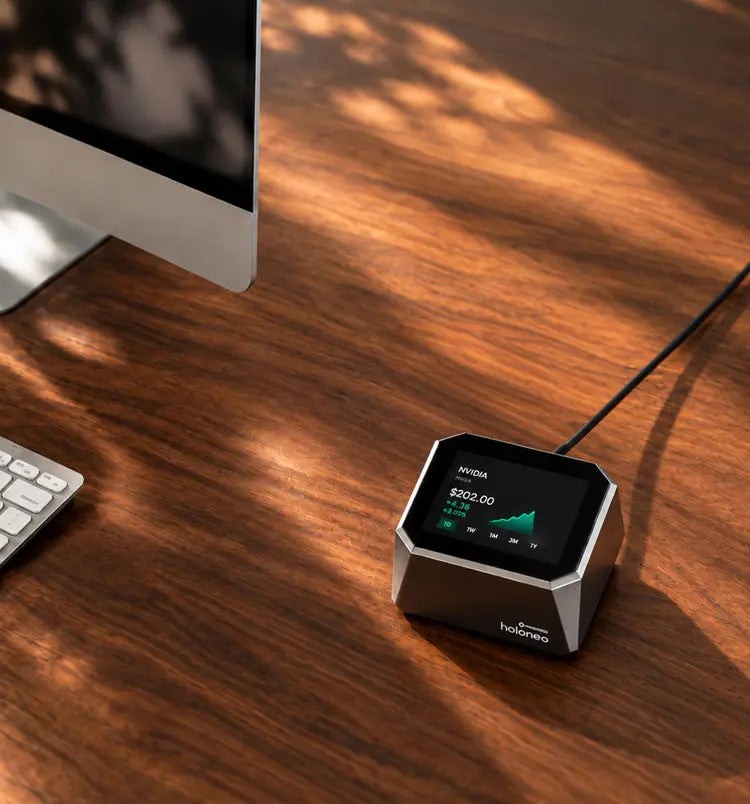 Holoneo cube on a wooden desk next to a keyboard and monitor