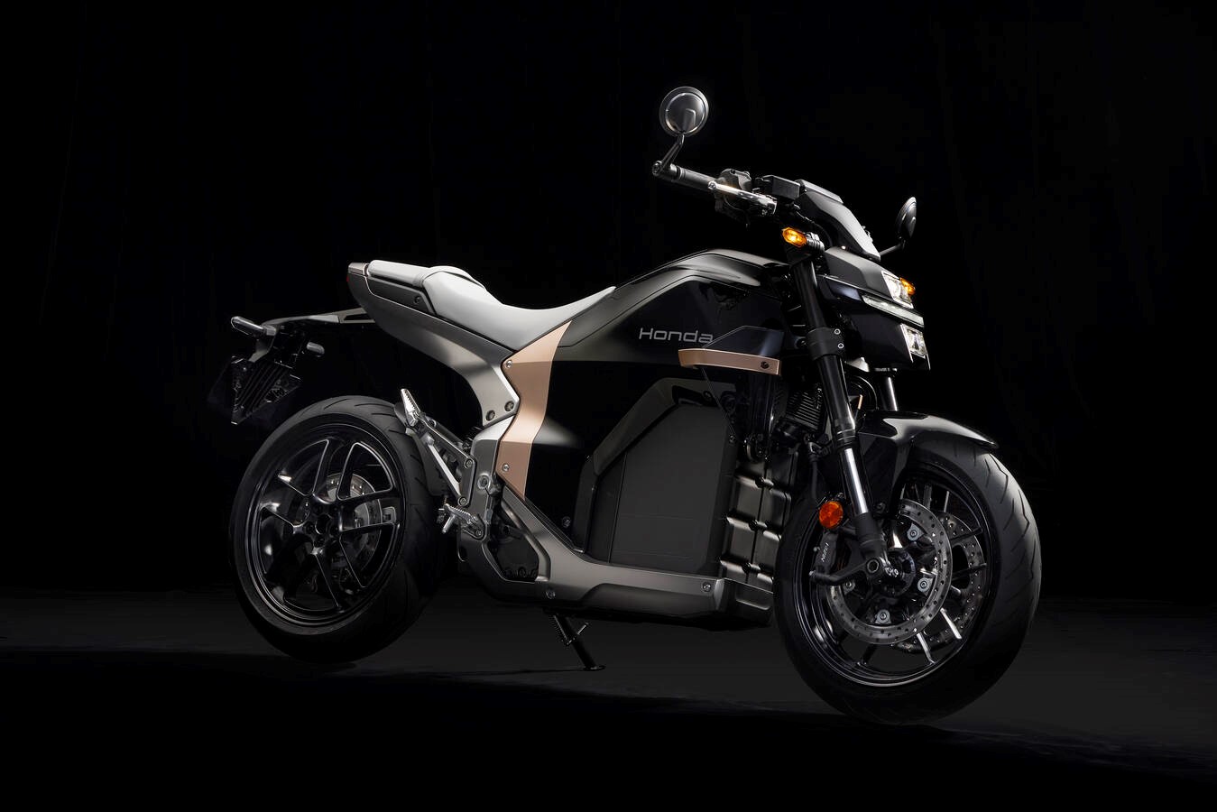 Honda WN7 naked electric motorcycle shown from the front three-quarter angle in a dark studio