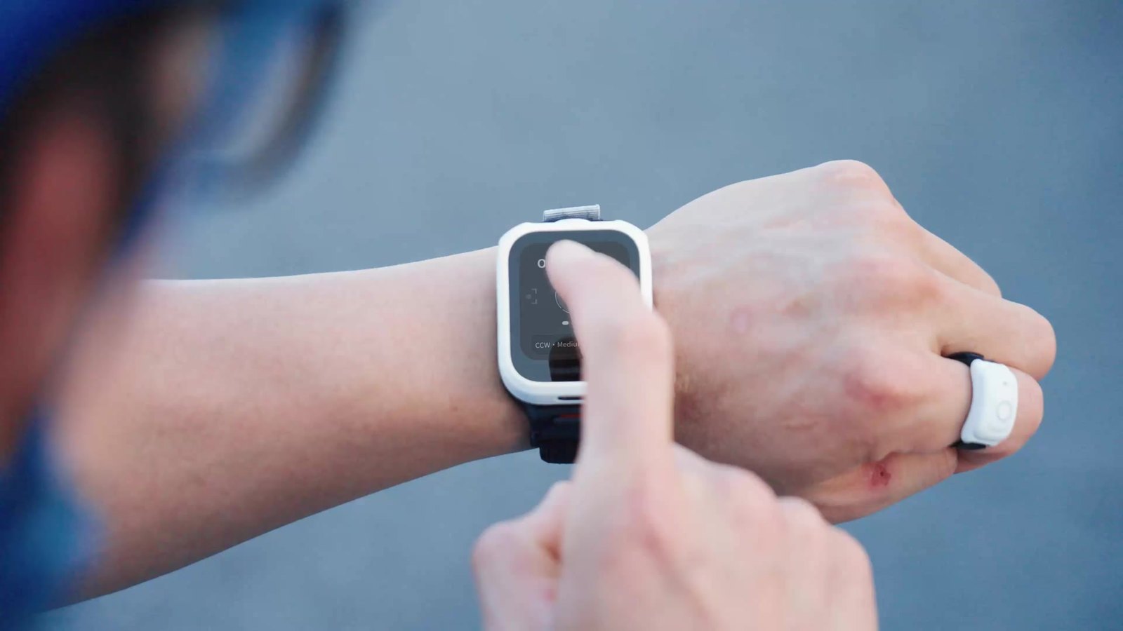 Hand tapping the Antigravity Watch Remote touchscreen while wearing the Ring Remote