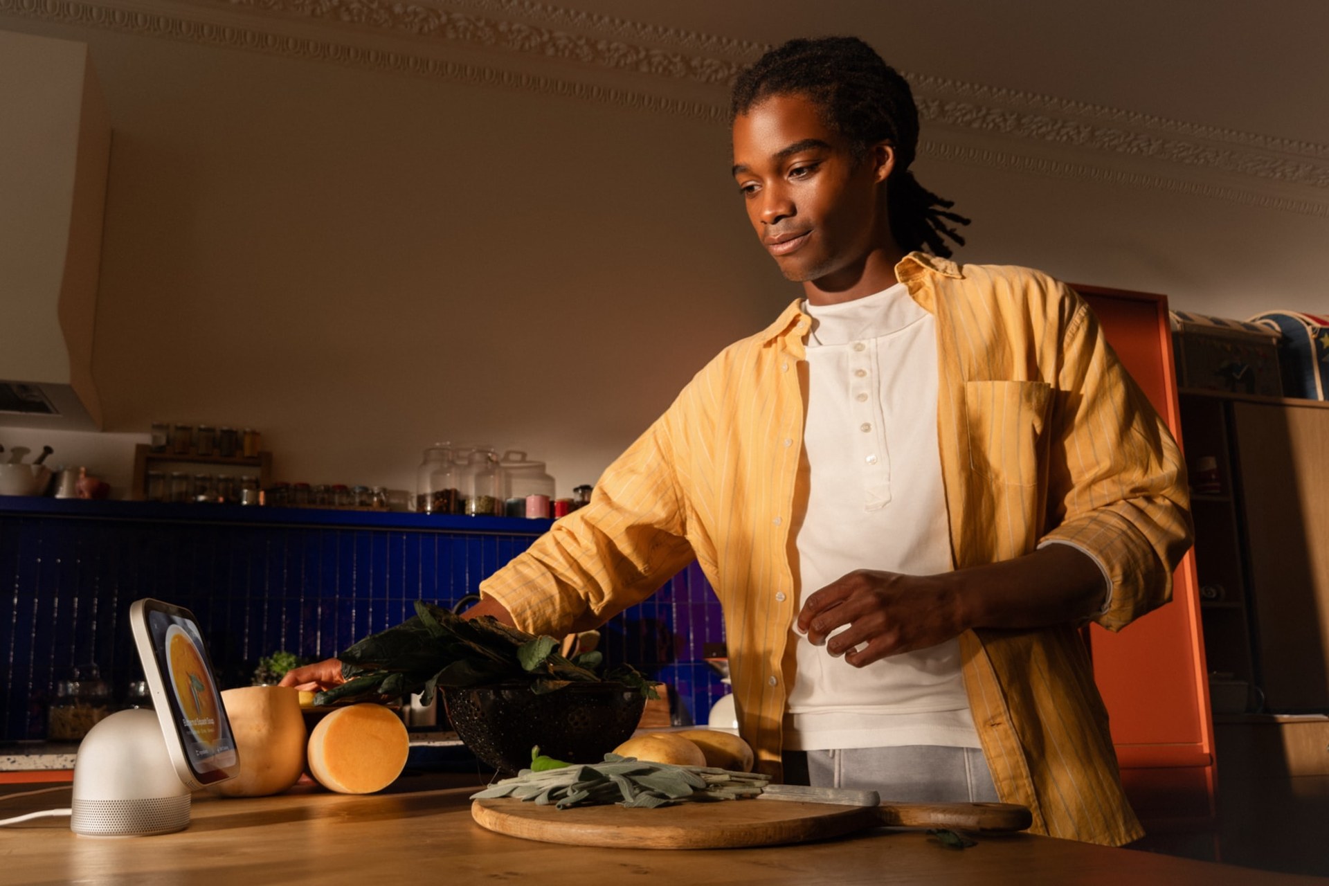 Person cooking in a kitchen with Apple HomeView on the counter