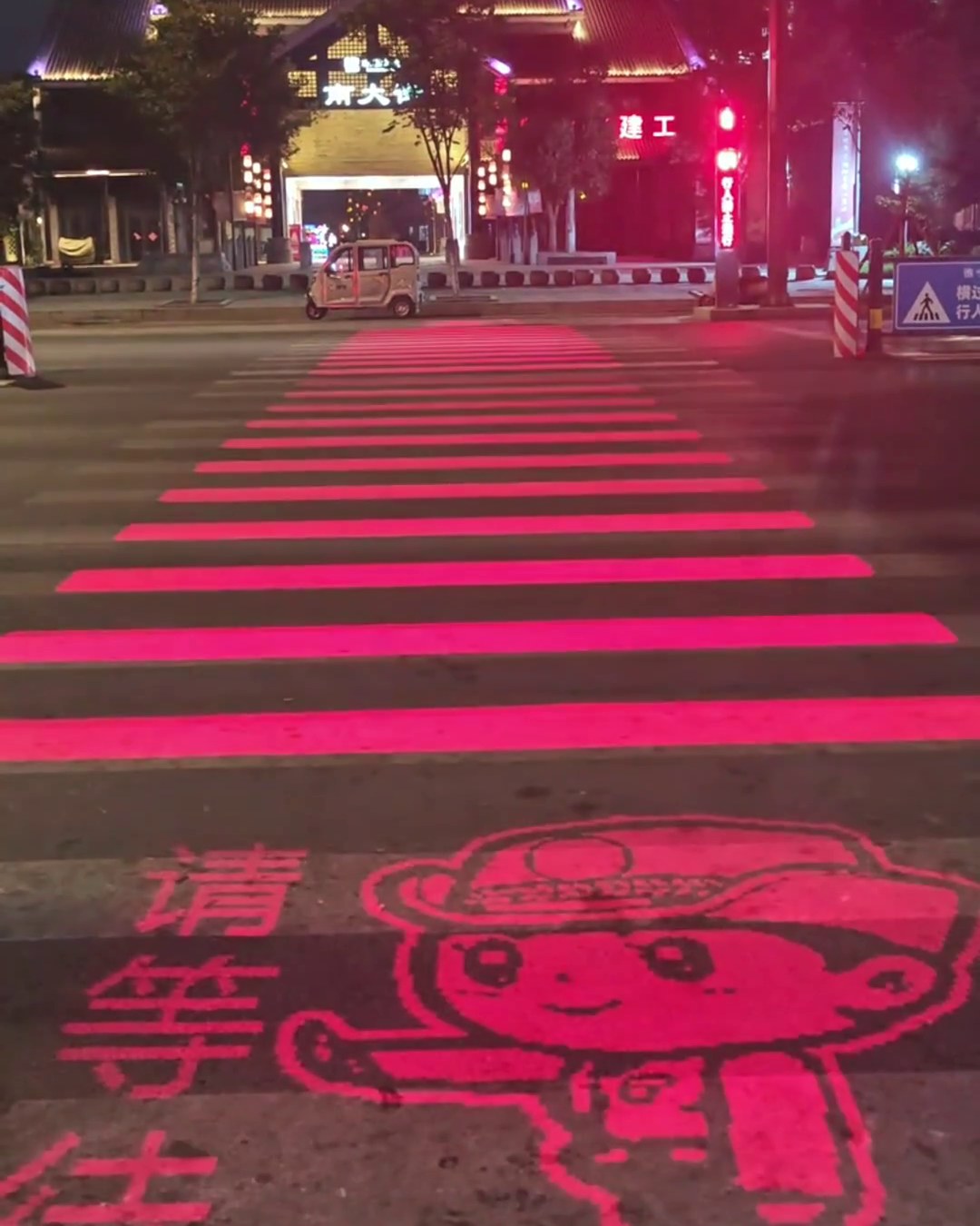 Red LED crosswalk showing a cartoon traffic officer telling pedestrians to wait