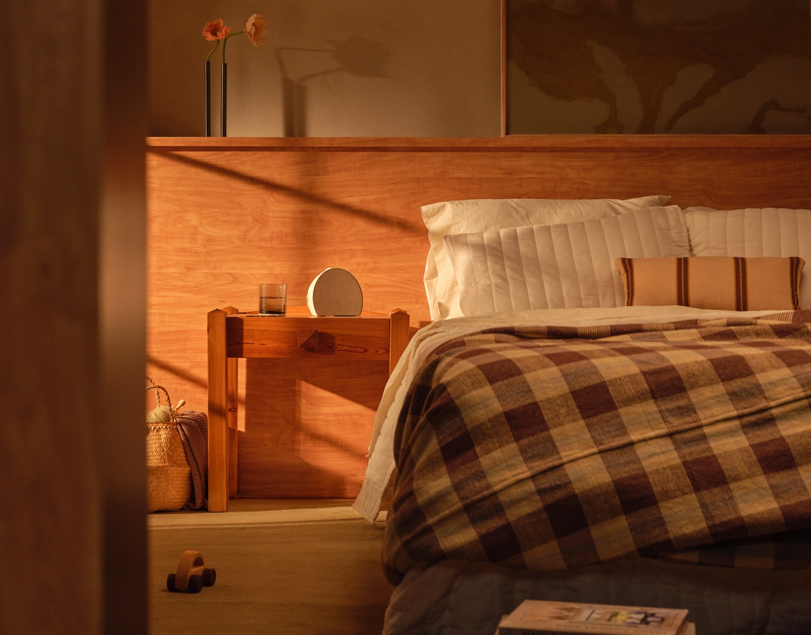 Hatch Sleep Clock on a bedside shelf in a warm-lit bedroom