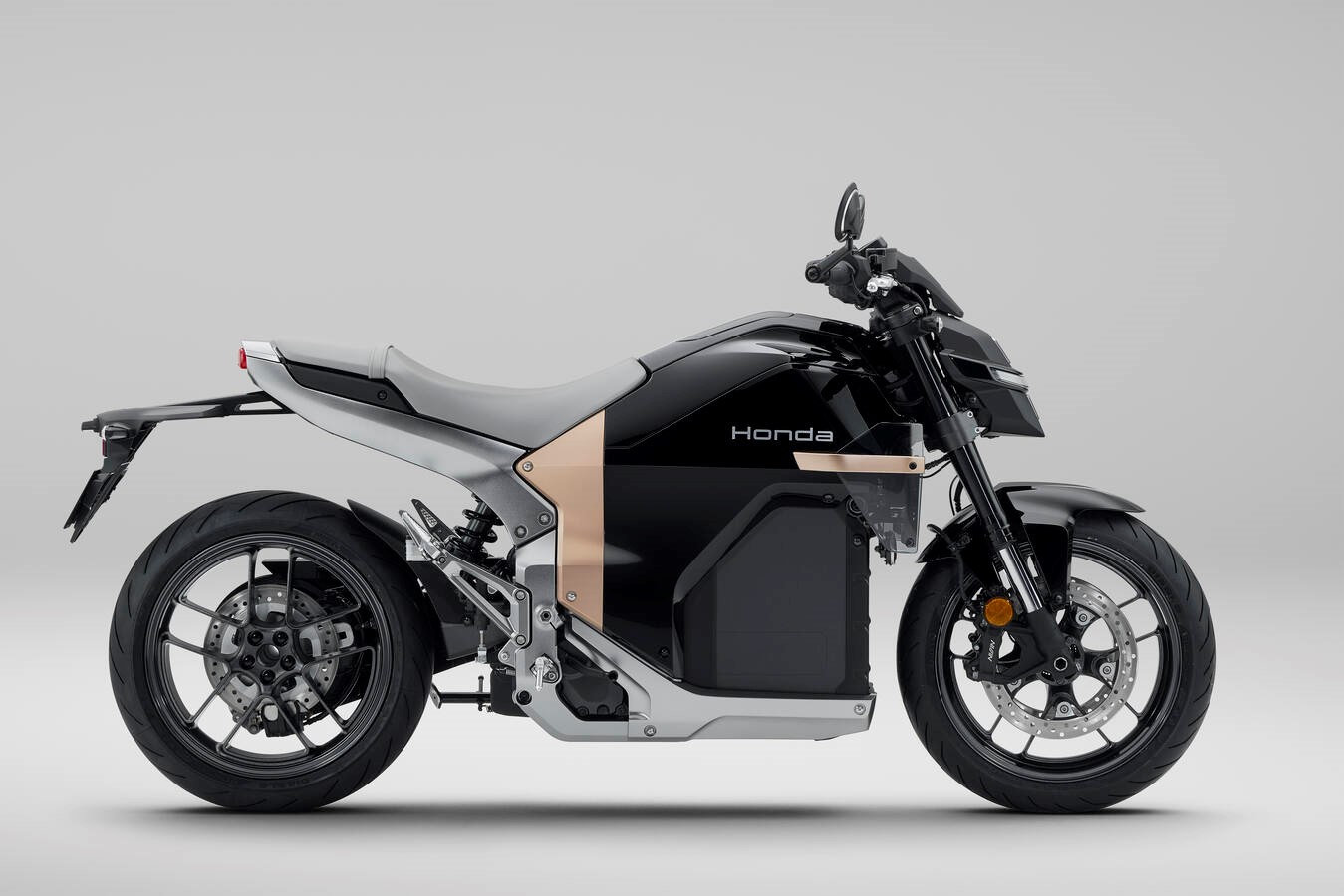Side profile of the Honda WN7 electric motorcycle showing the battery pack in the frame and the belt drive