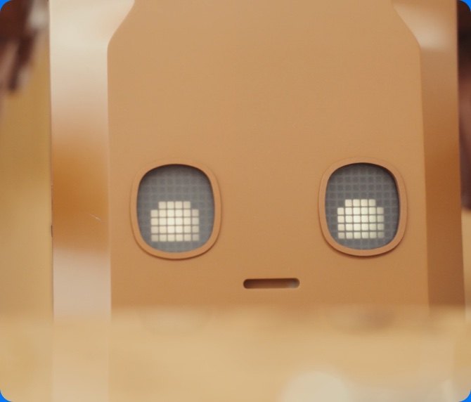Close up of the Voxel robot torso showing two pixelated LED eyes and a small mouth