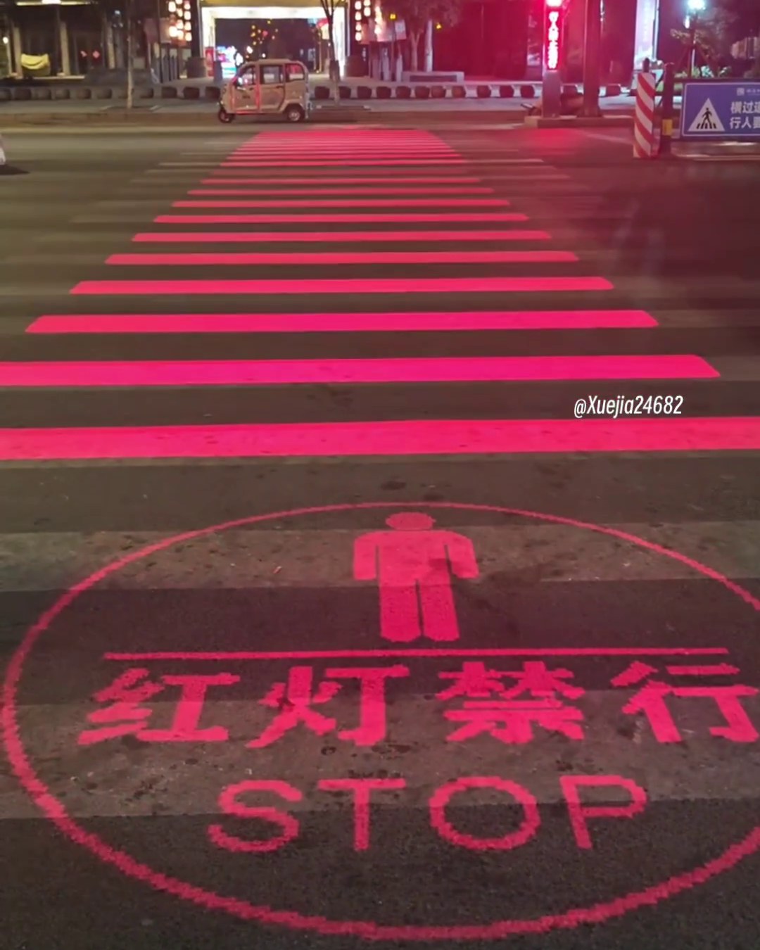Red LED crosswalk displaying a no-crossing STOP symbol on the pavement