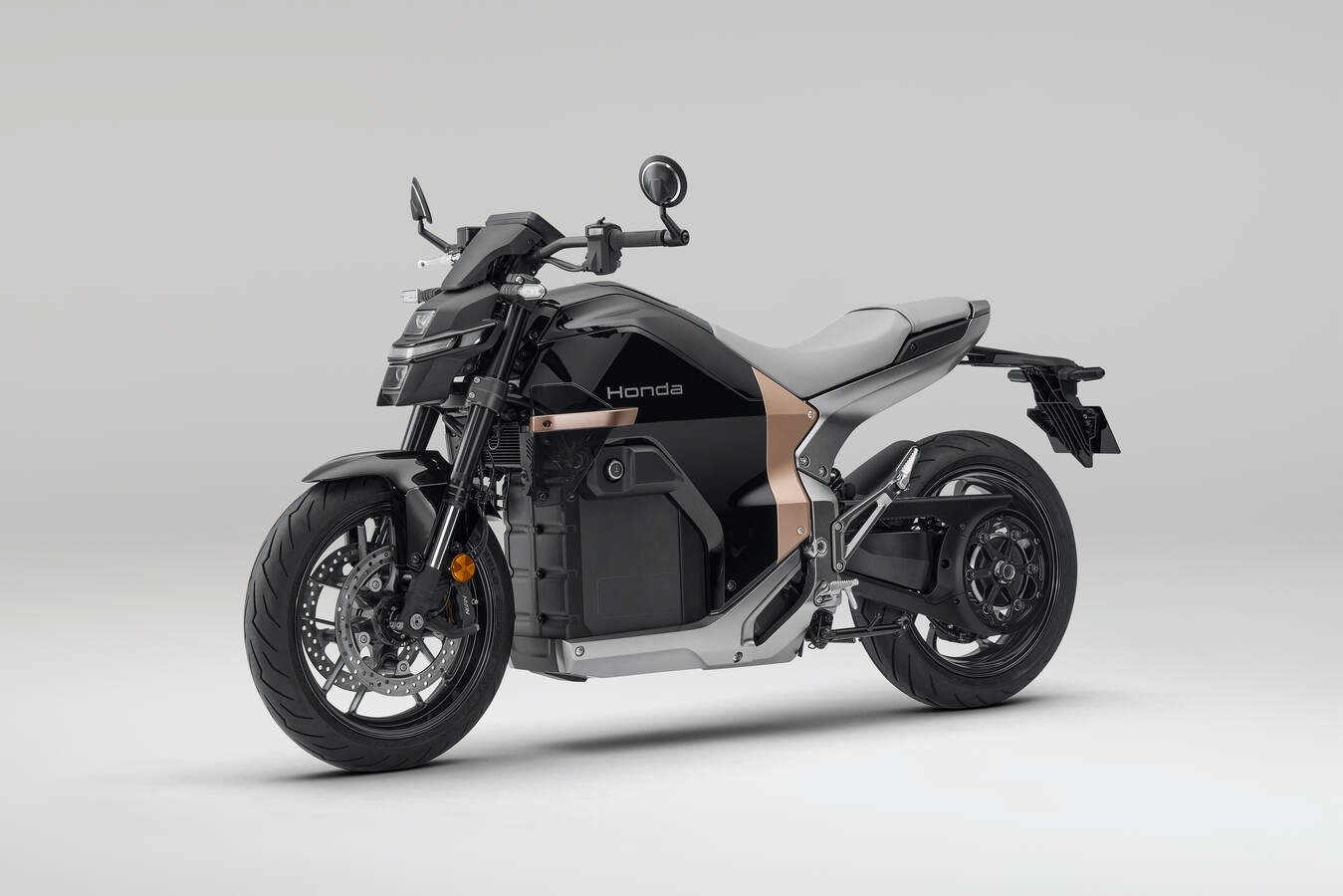Honda WN7 electric motorcycle in black with copper accents, front three-quarter view on a light gray background