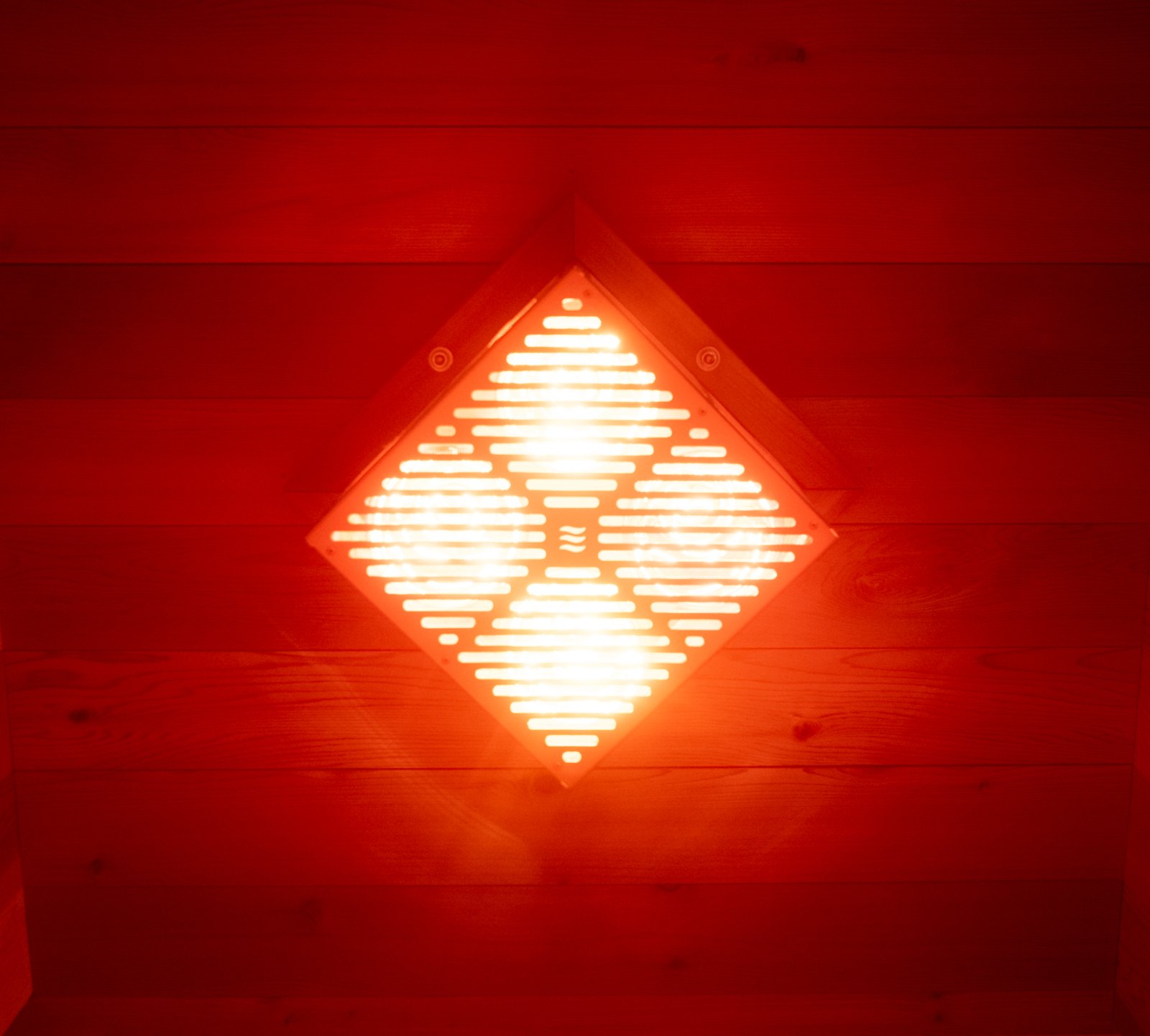 The Hot Box Sauna heater glowing bright red inside the cedar box