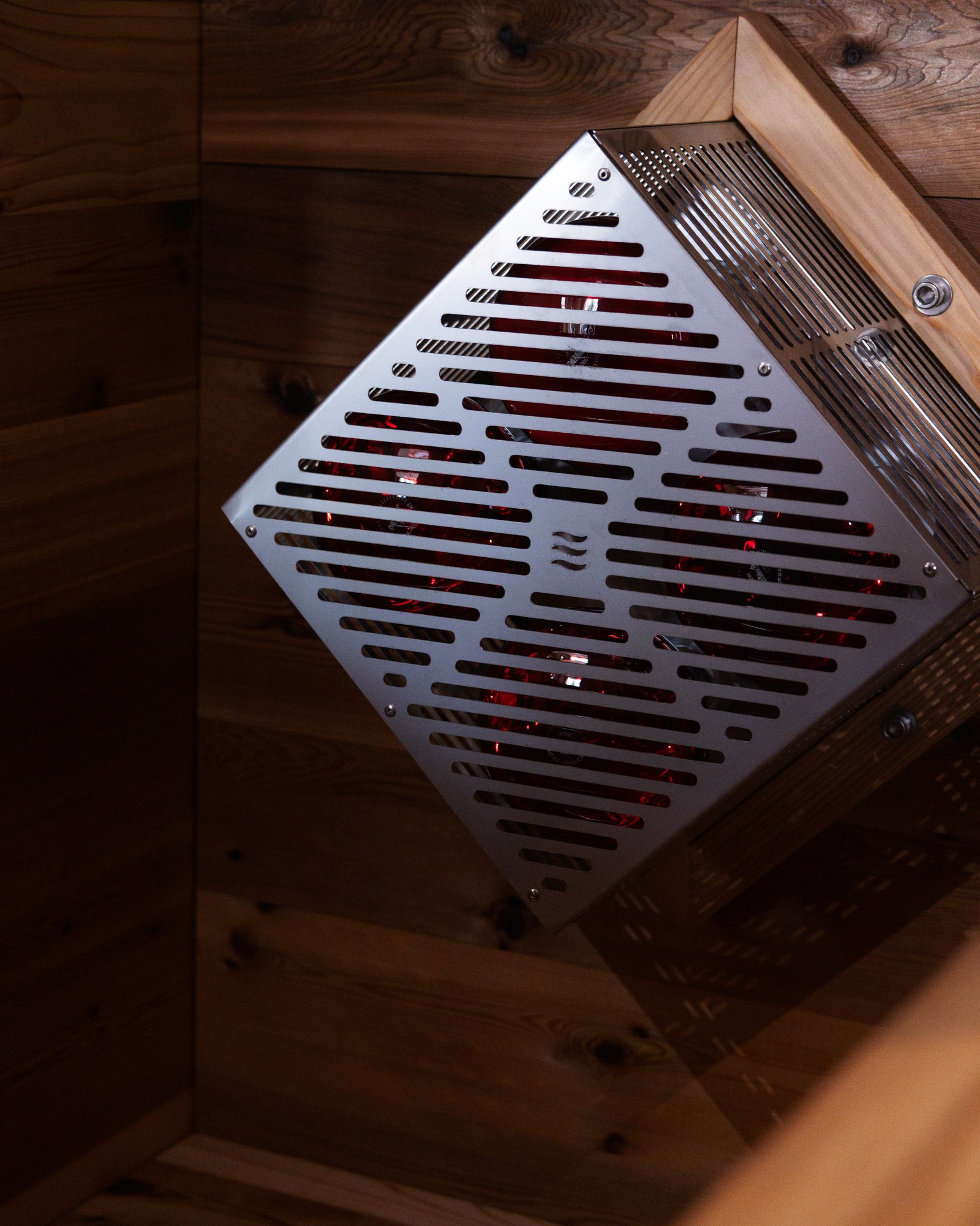 Laser-cut stainless steel heater cover mounted inside The Hot Box Sauna