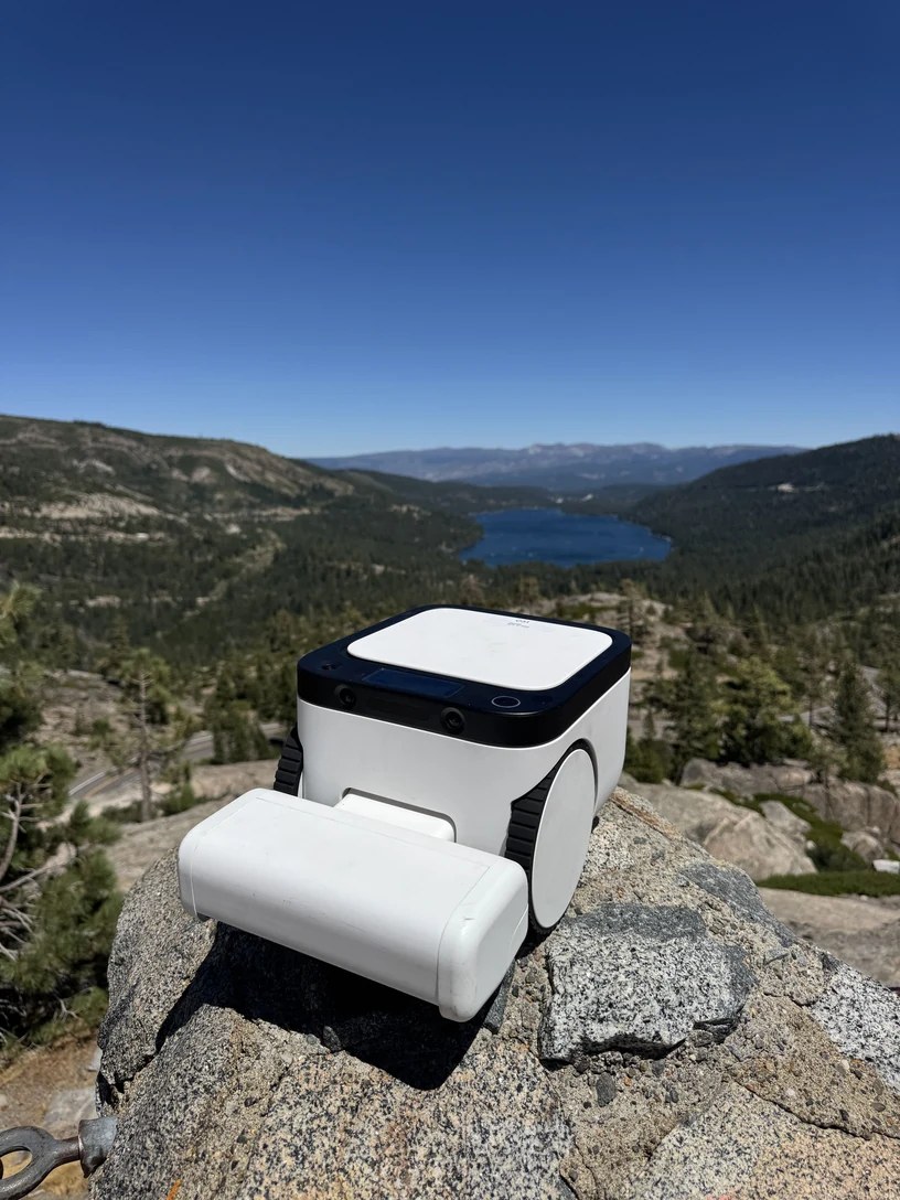 Matic robot vacuum perched on a rock above Lake Tahoe