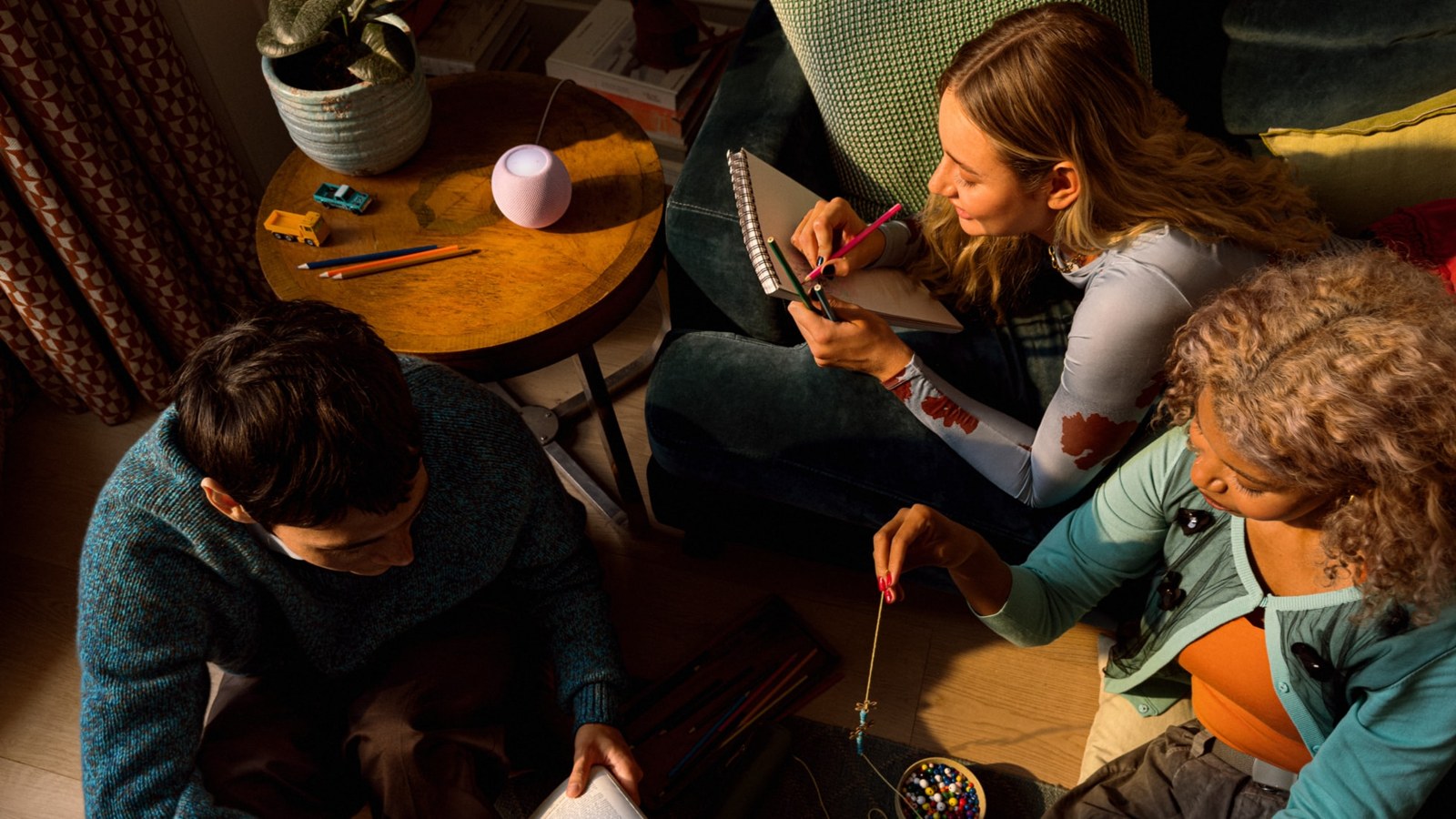 Family playing a board game with HomePod mini 2 on the table