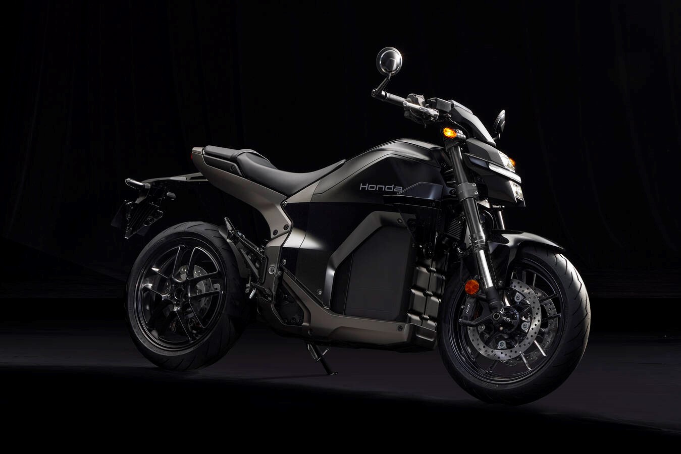 Honda WN7 electric motorcycle in dark black paint on a black studio background